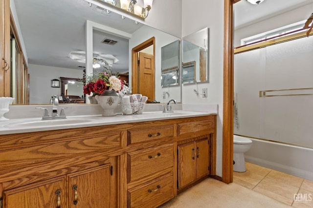 bathroom with tile patterned flooring, toilet, a sink, visible vents, and double vanity