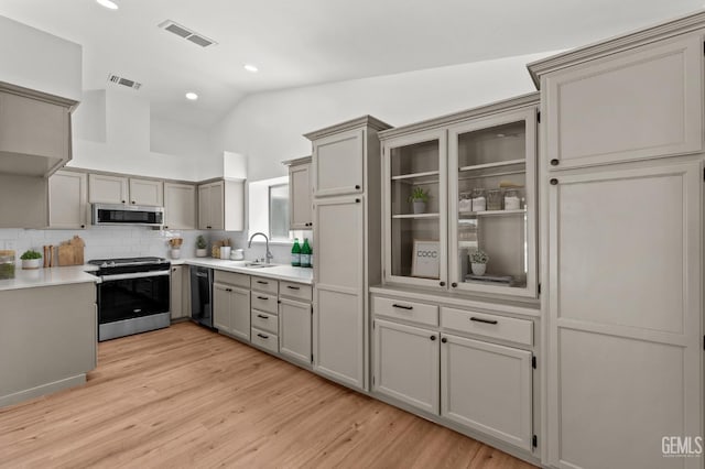 6201 Regina Way, Bakersfield, CA 93307 - kitchen featuring stainless steel appliances, a sink, light wood finished floors, lofted ceiling, and light countertops