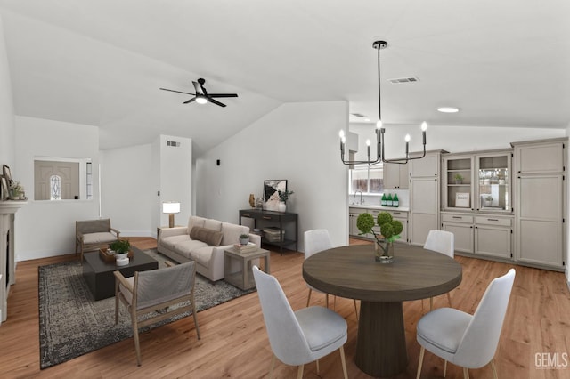 6201 Regina Way, Bakersfield, CA 93307 - dining space featuring lofted ceiling, light wood-type flooring, a chandelier, and a ceiling fan
