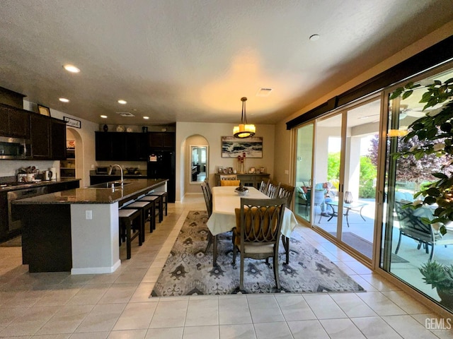15209 Aldridge Ave, Bakersfield, CA 93314 - dining space featuring arched walkways, recessed lighting, light tile patterned floors, and a textured ceiling
