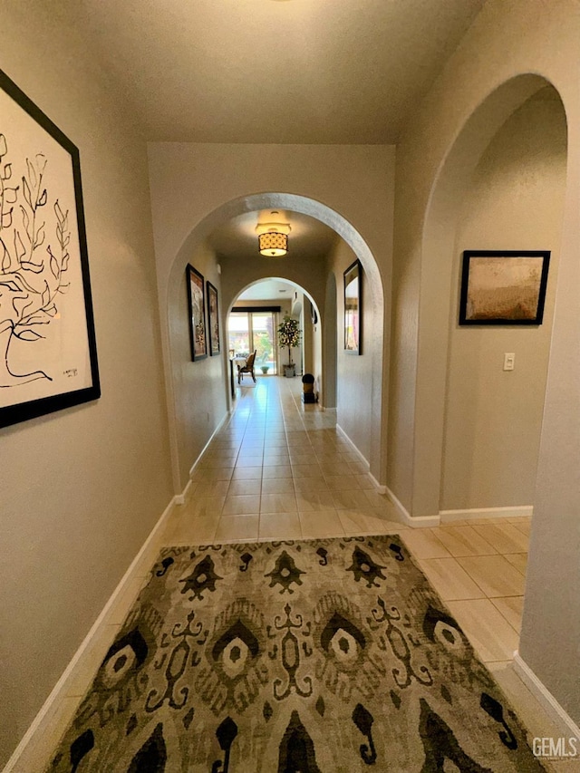 15209 Aldridge Ave, Bakersfield, CA 93314 - hallway with arched walkways, light tile patterned floors, and baseboards