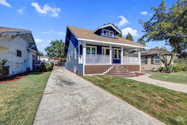 bungalow-style home featuring covered porch and a front yard