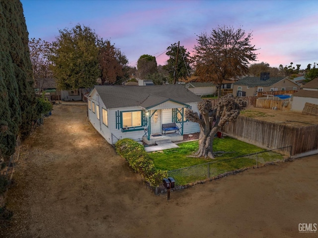 bungalow-style house featuring a fenced backyard and a yard