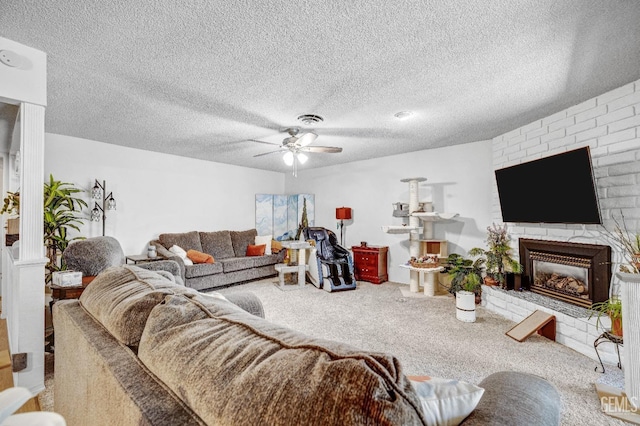 carpeted living room with ceiling fan, a textured ceiling, and a brick fireplace