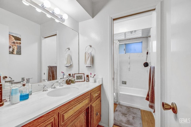 bathroom with hardwood / wood-style flooring, vanity, and shower / tub combo