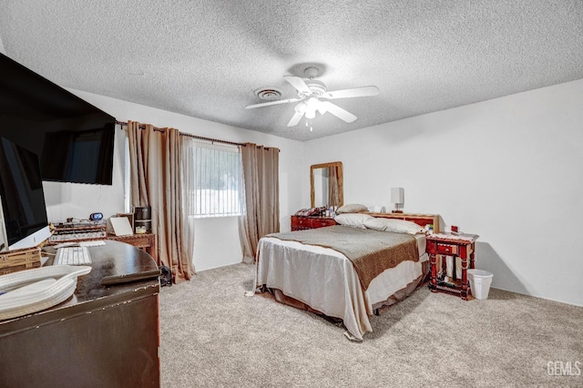 bedroom with ceiling fan, light colored carpet, and a textured ceiling