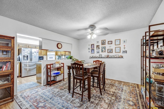 dining space featuring ceiling fan, light hardwood / wood-style floors, and a textured ceiling