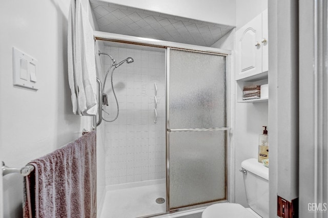 bathroom with toilet and a shower with shower door