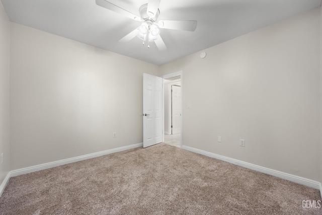 carpeted empty room featuring baseboards and ceiling fan