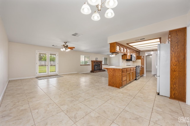 kitchen featuring brown cabinetry, light tile patterned floors, appliances with stainless steel finishes, light countertops, and visible vents