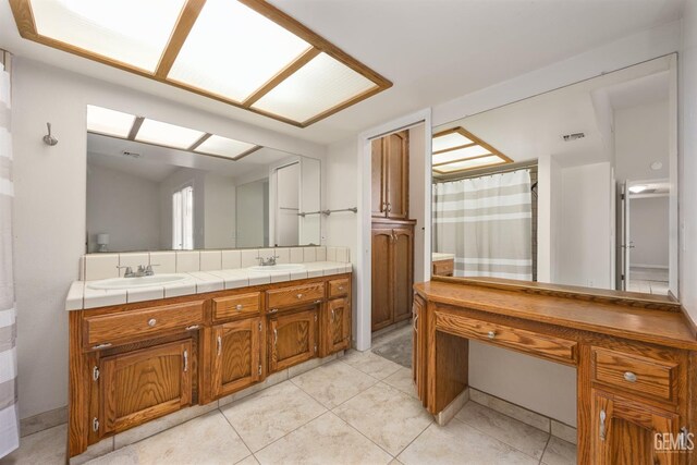 bathroom featuring double vanity, tile patterned floors, a shower with curtain, and a sink