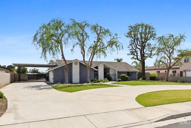 view of front of home featuring a front yard, curved driveway, and fence
