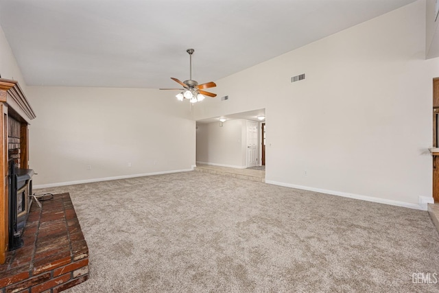 unfurnished living room featuring a wood stove, ceiling fan, visible vents, baseboards, and carpet floors