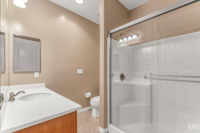 bathroom with tile patterned flooring, vanity, a shower with shower door, and toilet