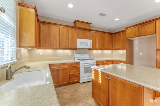 kitchen featuring sink, white appliances, light stone countertops, and light tile patterned floors