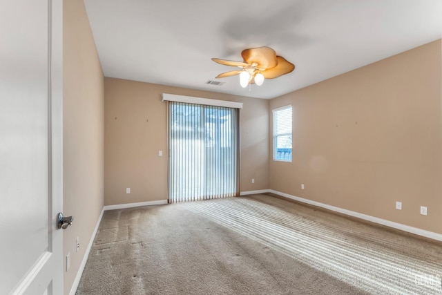 carpeted spare room featuring ceiling fan