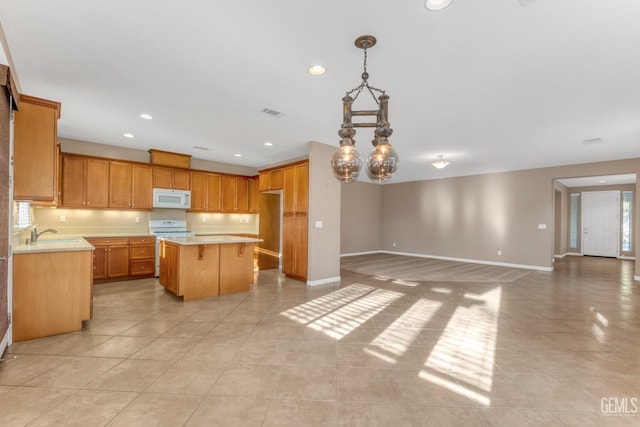 kitchen featuring hanging light fixtures, white appliances, light tile patterned floors, and a kitchen island