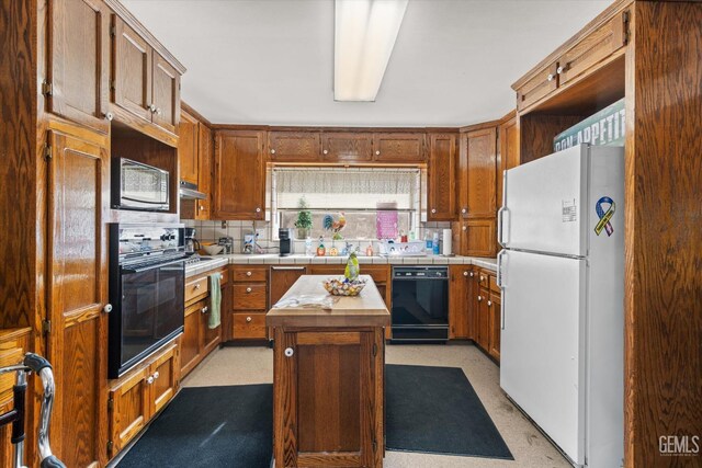 kitchen featuring black appliances, a kitchen island, and tasteful backsplash