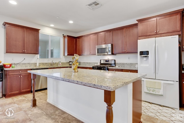 7327 Glitter Way, Bakersfield, CA 93313 - kitchen with appliances with stainless steel finishes, recessed lighting, a kitchen island, light stone countertops, and a breakfast bar area