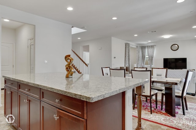 7327 Glitter Way, Bakersfield, CA 93313 - kitchen featuring open floor plan, recessed lighting, a breakfast bar, a kitchen island, and light stone counters