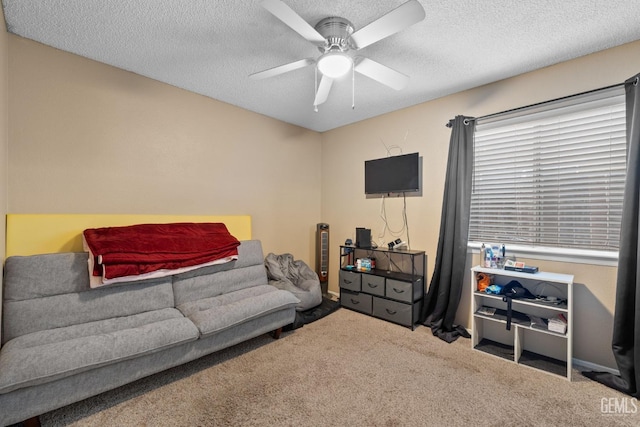 living room with a ceiling fan, a textured ceiling, and carpet