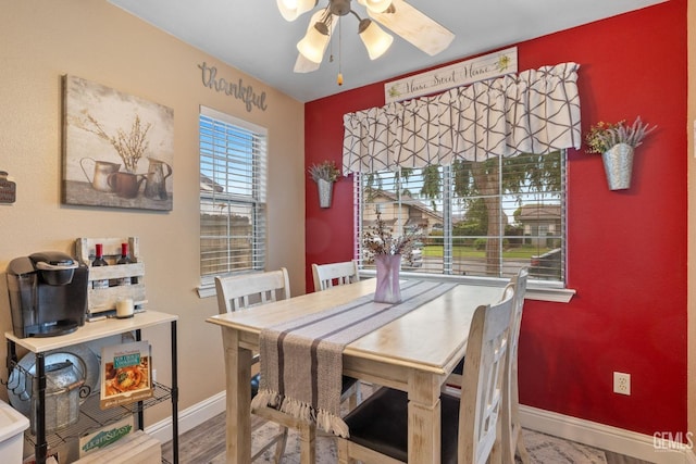 dining area with baseboards, ceiling fan, and wood finished floors