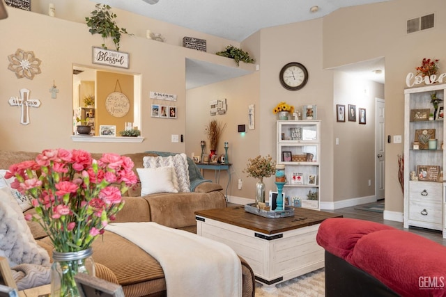 living area featuring visible vents, baseboards, and wood finished floors