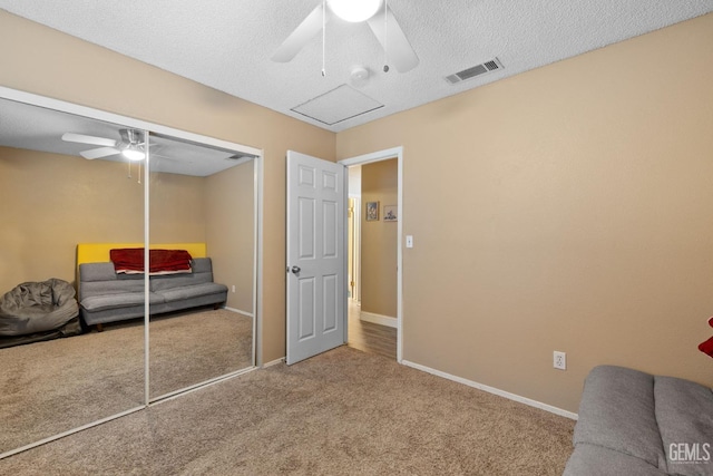 carpeted bedroom featuring a ceiling fan, a textured ceiling, visible vents, baseboards, and a closet