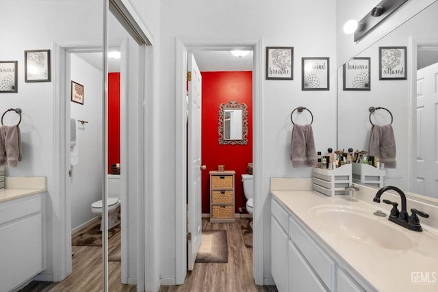 bathroom featuring vanity, toilet, and wood finished floors