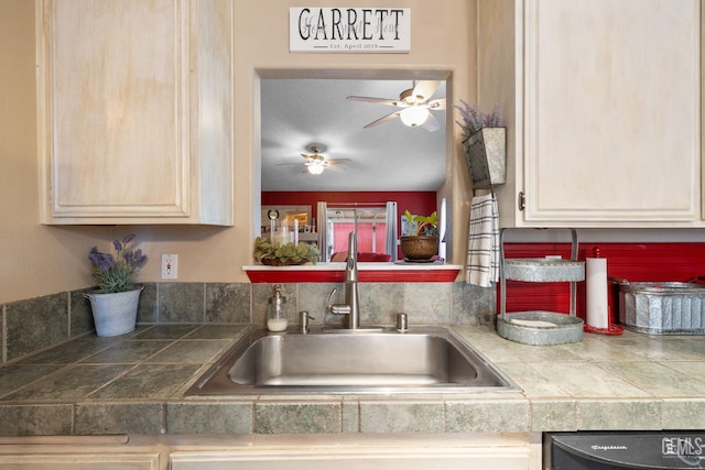 kitchen with a sink, tile counters, a ceiling fan, and dishwasher