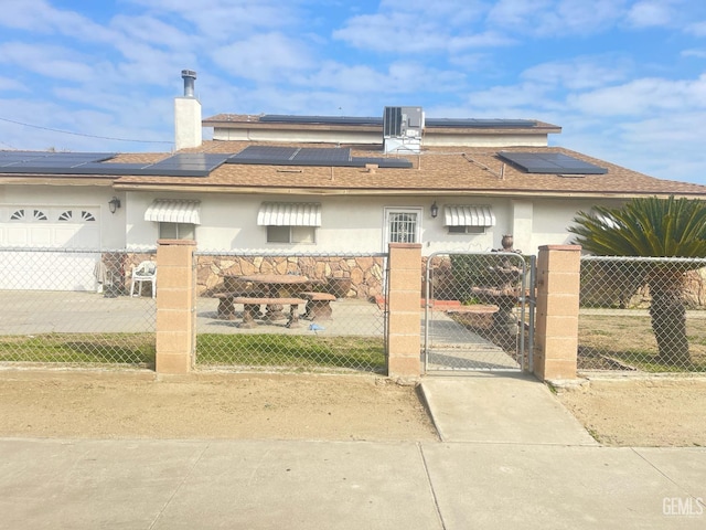 view of front of property featuring central AC unit and solar panels