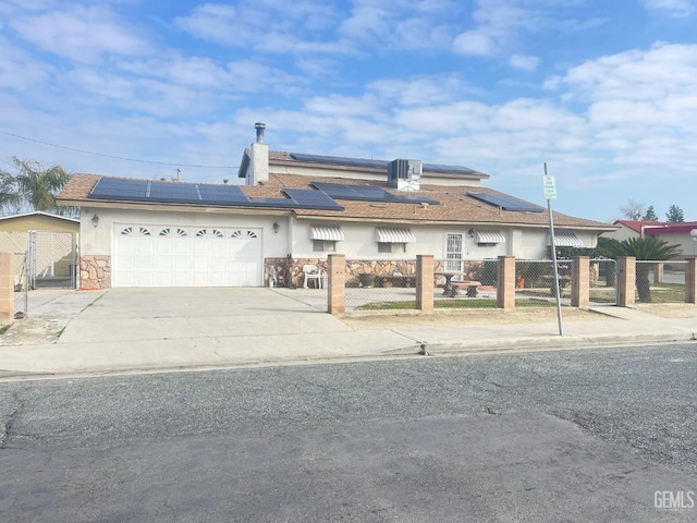 view of front of property featuring central AC, a garage, and solar panels