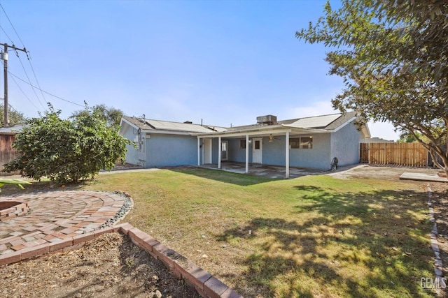 rear view of property with a yard and a patio area