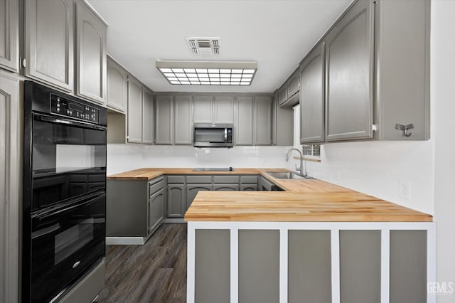 kitchen featuring sink, gray cabinetry, butcher block countertops, and double oven