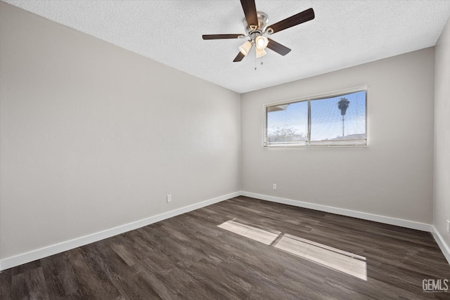 empty room featuring ceiling fan, dark wood-type flooring, and a textured ceiling