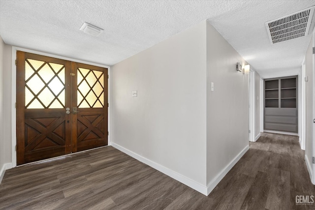 entryway featuring dark wood-type flooring and a textured ceiling