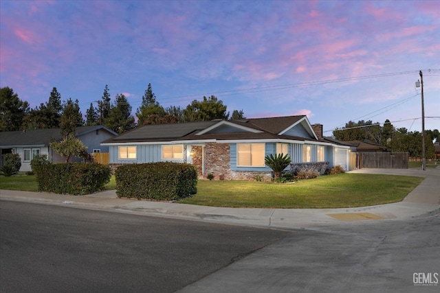 single story home with a lawn and solar panels