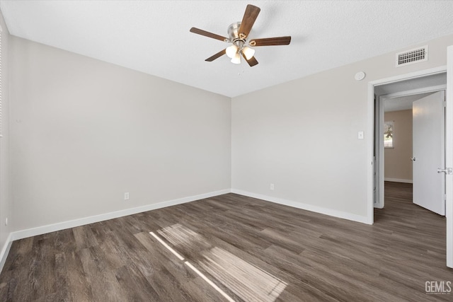 unfurnished room featuring dark wood-type flooring, ceiling fan, and a textured ceiling