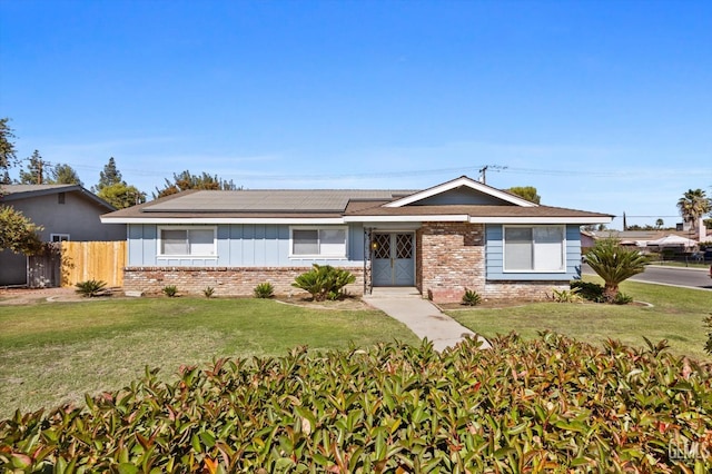 ranch-style house featuring a front lawn and solar panels