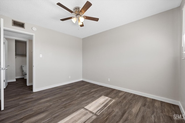 empty room featuring ceiling fan, dark hardwood / wood-style floors, and a textured ceiling