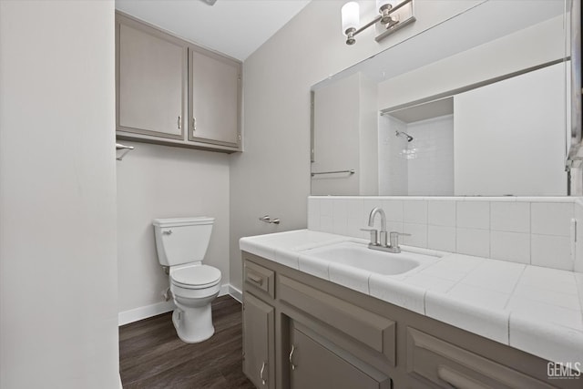 bathroom featuring vanity, wood-type flooring, walk in shower, and toilet