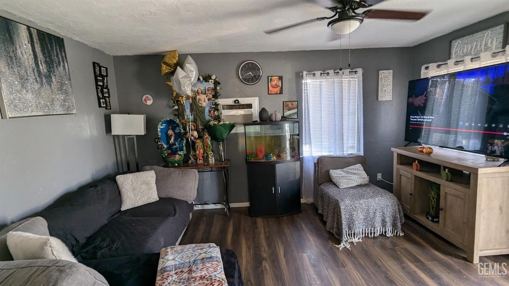 living room with ceiling fan, dark wood-type flooring, and a textured ceiling