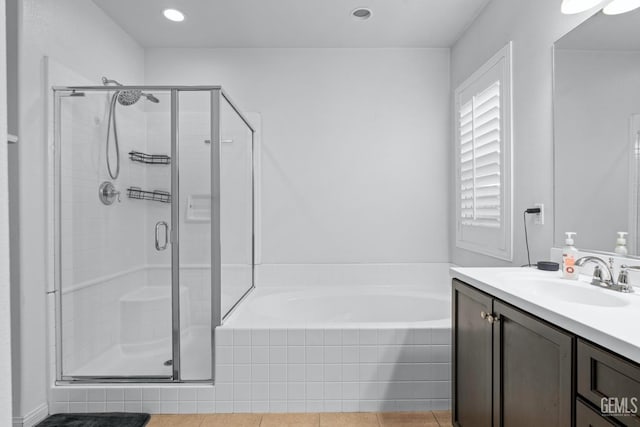 bathroom featuring vanity, a garden tub, and a stall shower