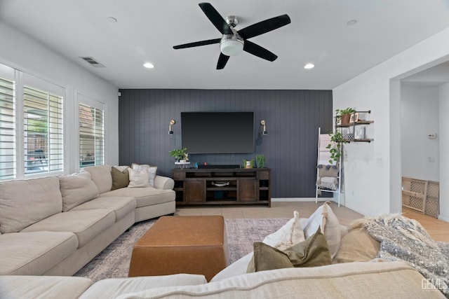 living room with recessed lighting, visible vents, ceiling fan, and an accent wall