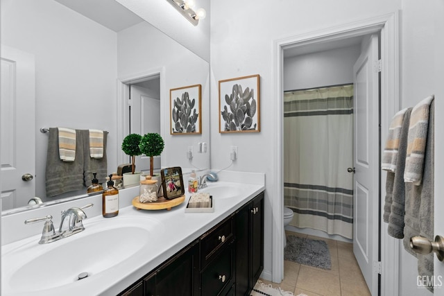 full bath with tile patterned floors, toilet, double vanity, and a sink