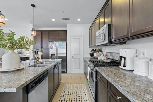 kitchen featuring visible vents, a sink, appliances with stainless steel finishes, light tile patterned floors, and dark brown cabinets