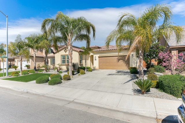 view of front of home featuring a tile roof, concrete driveway, an attached garage, and stucco siding