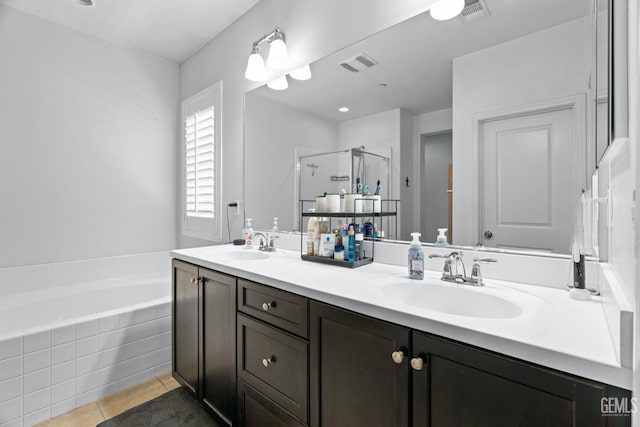 full bathroom with a shower stall, double vanity, visible vents, and a sink