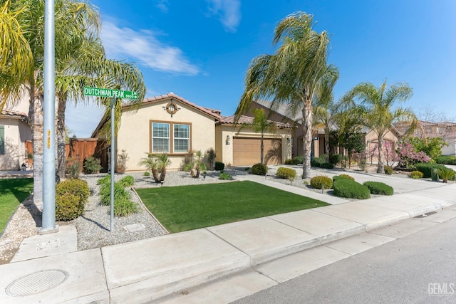 mediterranean / spanish home featuring a front lawn, fence, a tiled roof, concrete driveway, and stucco siding