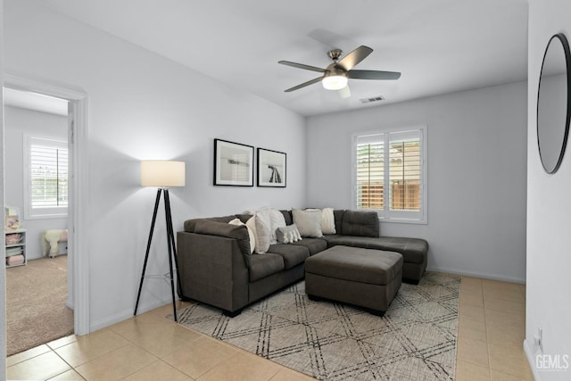 tiled living area with baseboards, visible vents, a wealth of natural light, and ceiling fan